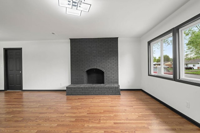 1727 Niagara Rd, Columbus, OH 43227 - unfurnished living room with light wood-style floors, baseboards, and a brick fireplace