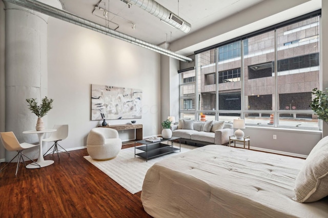bedroom with baseboards, multiple windows, wood finished floors, and visible vents