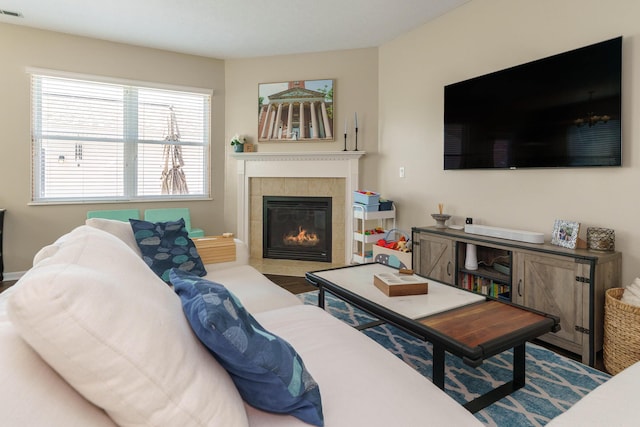 living area featuring visible vents and a tile fireplace