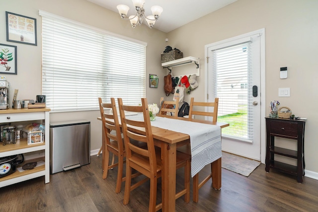 dining space featuring baseboards, plenty of natural light, dark wood-type flooring, and a chandelier