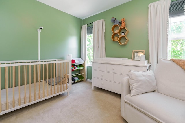 bedroom with a crib and light carpet