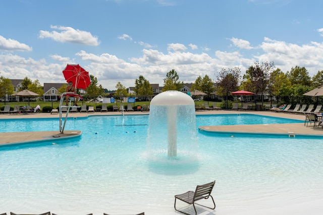 community pool with a patio and fence
