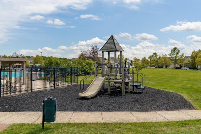 community play area featuring a yard, fence, and a community pool