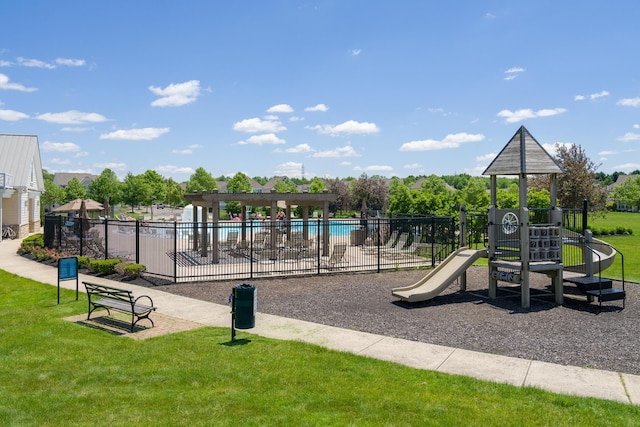 community jungle gym featuring fence, a community pool, and a yard