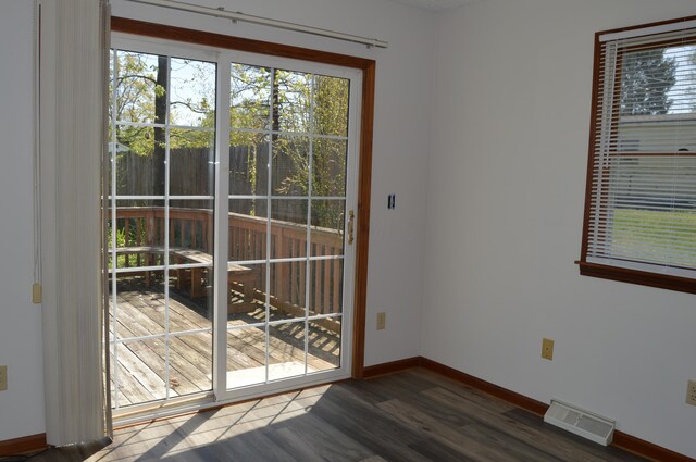 doorway to outside with baseboards, dark wood-style flooring, and visible vents