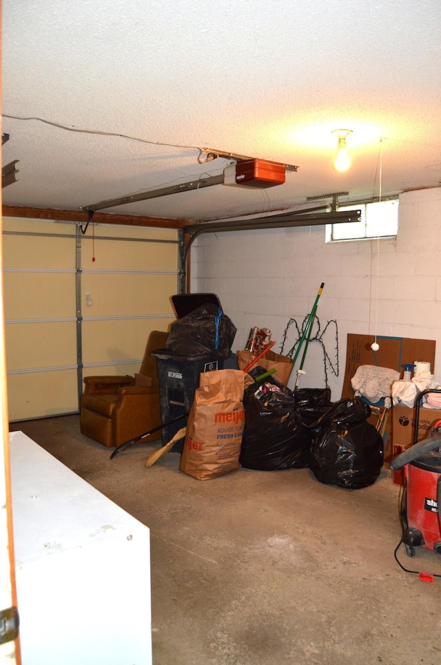 garage with concrete block wall and a garage door opener