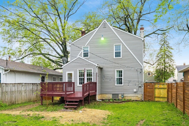back of house with a fenced backyard, a wooden deck, a chimney, and a lawn