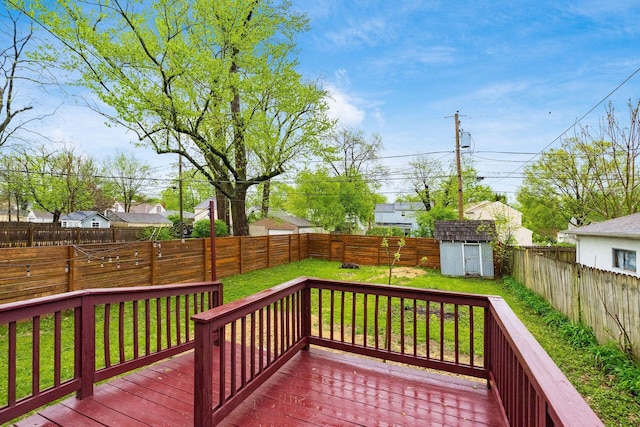deck featuring a lawn, an outbuilding, a fenced backyard, and a shed