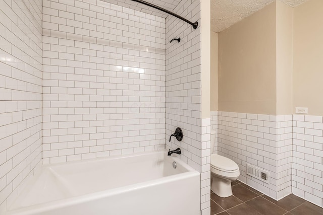 full bathroom with shower / tub combination, toilet, a textured ceiling, tile walls, and visible vents