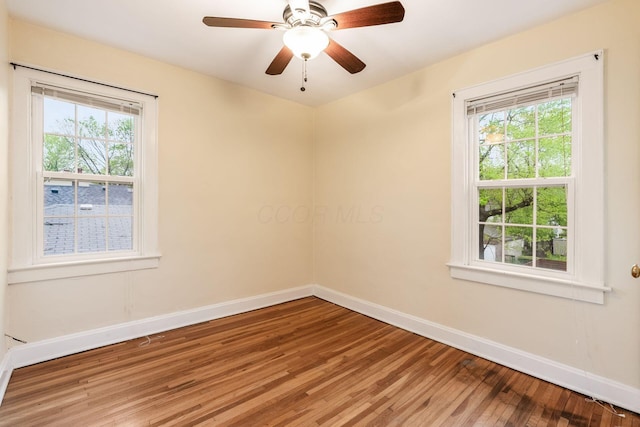 spare room with baseboards, light wood finished floors, and a wealth of natural light