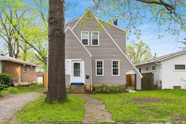 view of front of property featuring entry steps, an outbuilding, a chimney, and a storage shed