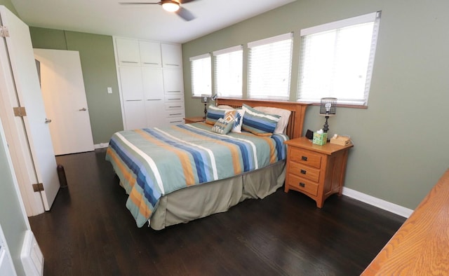 bedroom featuring a ceiling fan, baseboards, dark wood finished floors, and a closet