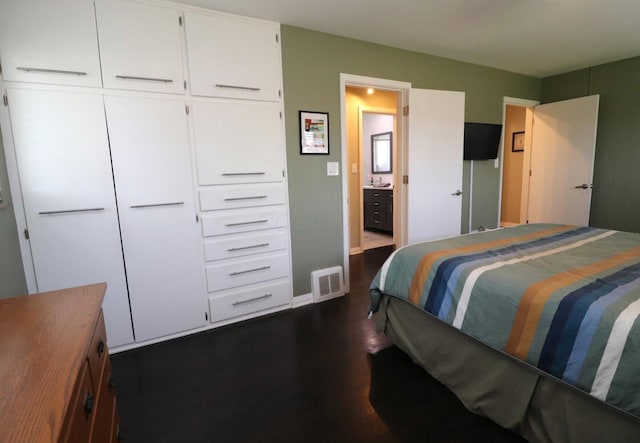 bedroom featuring dark wood finished floors, connected bathroom, and visible vents