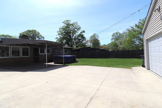 view of patio / terrace featuring fence, a fenced in pool, driveway, and a garage