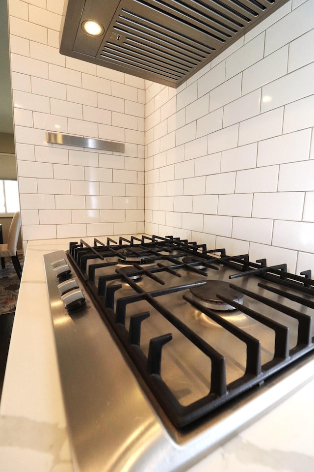details featuring recessed lighting, ventilation hood, tasteful backsplash, and stainless steel gas stovetop