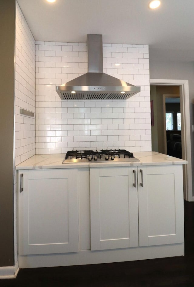 kitchen featuring recessed lighting, decorative backsplash, stainless steel gas stovetop, and wall chimney exhaust hood