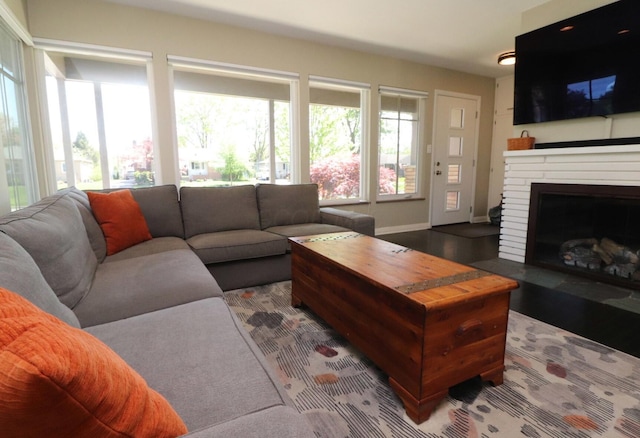 living area with plenty of natural light, baseboards, and a fireplace