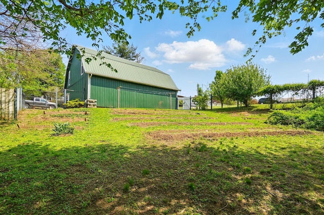 view of yard featuring fence, a pole building, and an outdoor structure