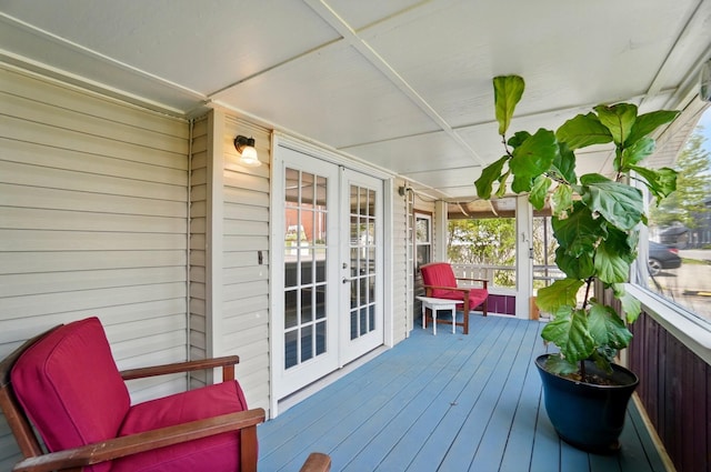 wooden terrace with a porch and french doors