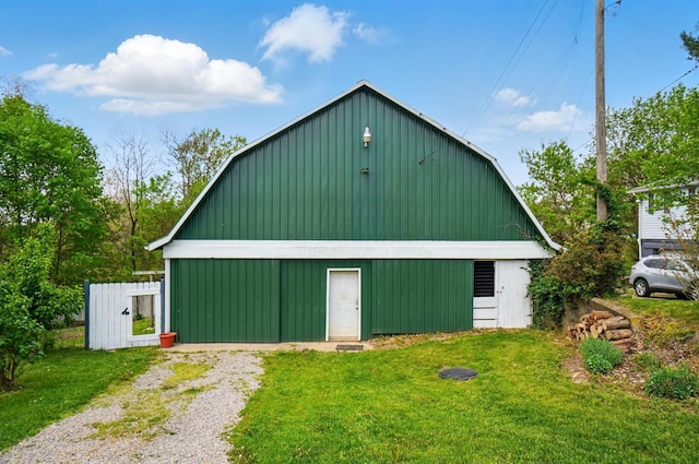 view of barn featuring a lawn and driveway