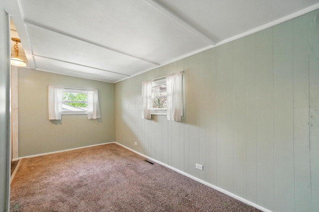 carpeted spare room featuring baseboards and visible vents