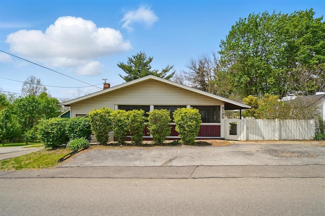 bungalow-style home featuring fence and a chimney