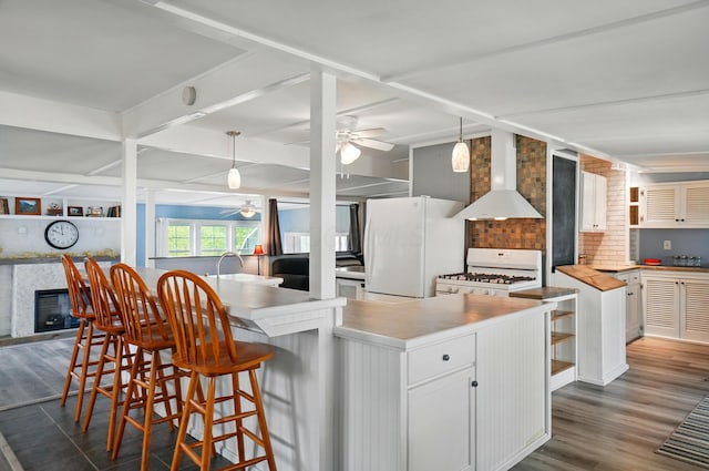 kitchen with open shelves, white appliances, ceiling fan, dark wood-style floors, and wall chimney range hood