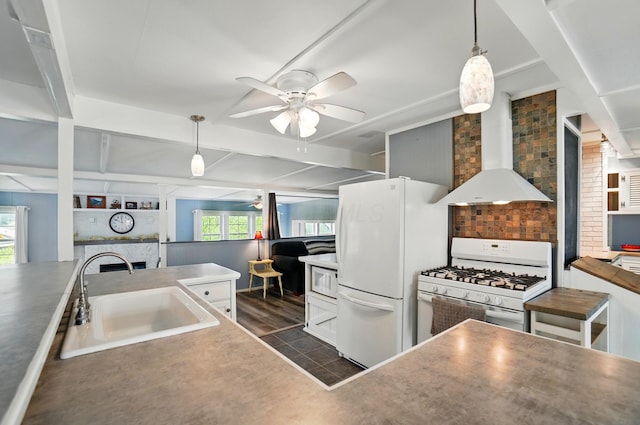 kitchen featuring a ceiling fan, pendant lighting, white appliances, wall chimney exhaust hood, and a sink