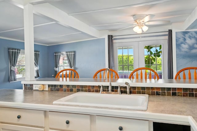 kitchen featuring a sink, ceiling fan, and white cabinets