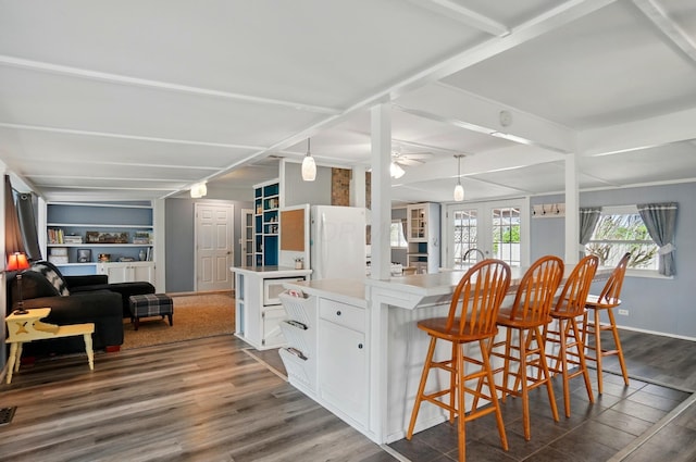 kitchen with a kitchen breakfast bar, a large island, white cabinets, dark wood-style floors, and open floor plan