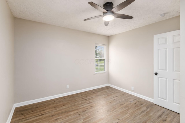 spare room featuring a textured ceiling, ceiling fan, baseboards, and light wood-style floors