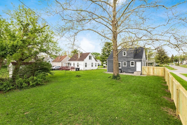 view of yard with fence, an outbuilding, and entry steps