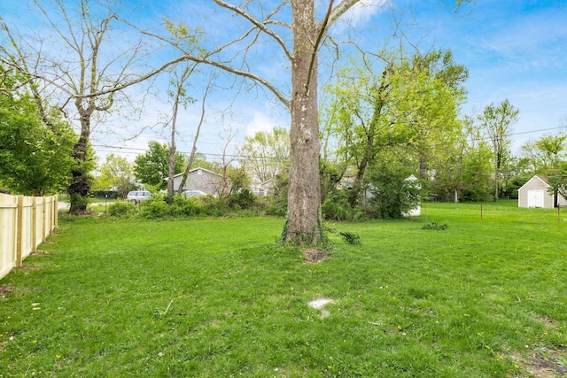view of yard with fence and an outbuilding