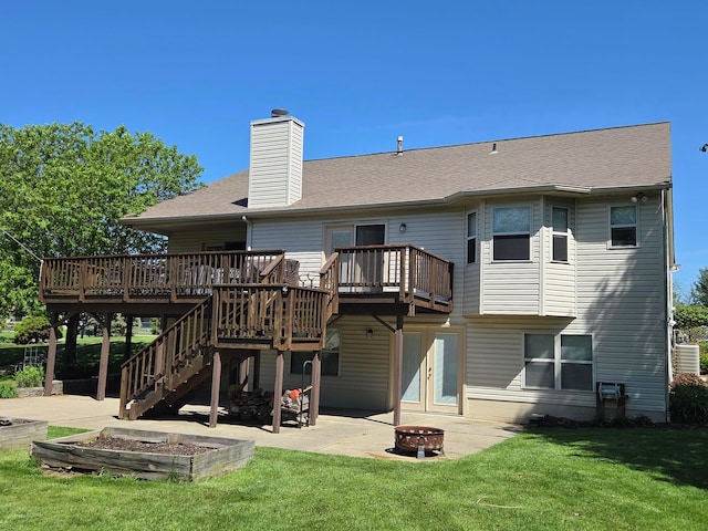 rear view of house with an outdoor fire pit, a wooden deck, and a patio
