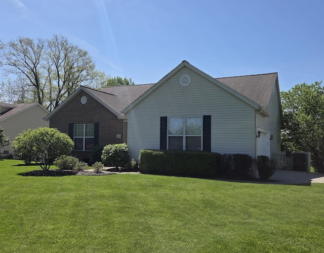 ranch-style house featuring a front yard, a shingled roof, and a garage