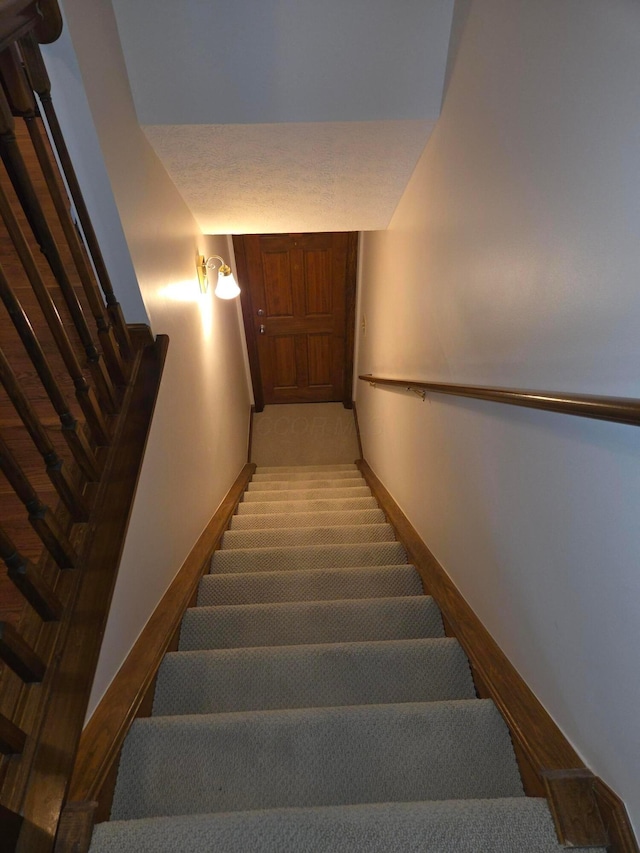 stairway featuring baseboards