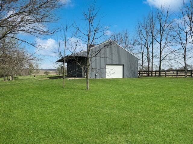 view of outdoor structure featuring fence and an outbuilding