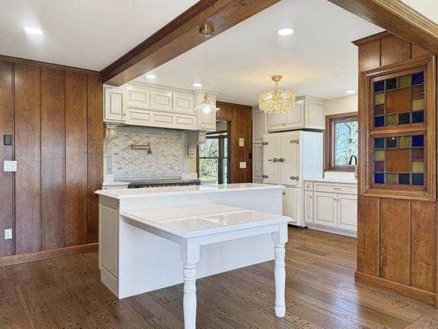kitchen featuring light countertops, dark wood-style flooring, and wooden walls