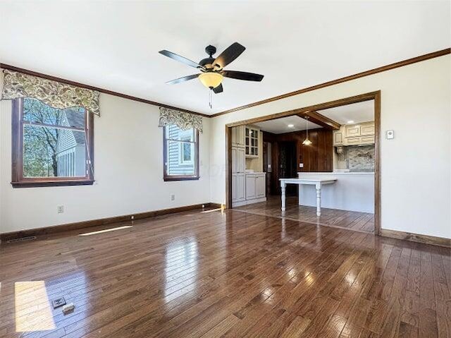 unfurnished living room with ornamental molding, a ceiling fan, and hardwood / wood-style flooring