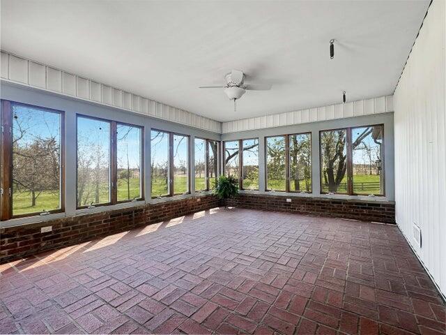 unfurnished sunroom with plenty of natural light and brick floor