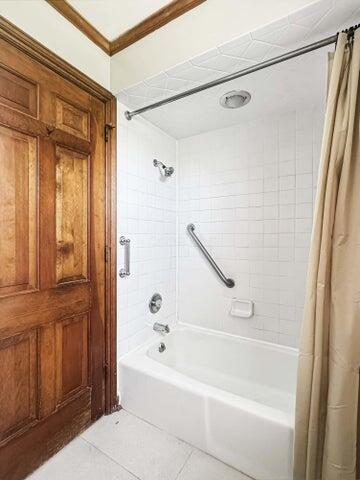 full bath with tile patterned flooring, shower / tub combo with curtain, and crown molding