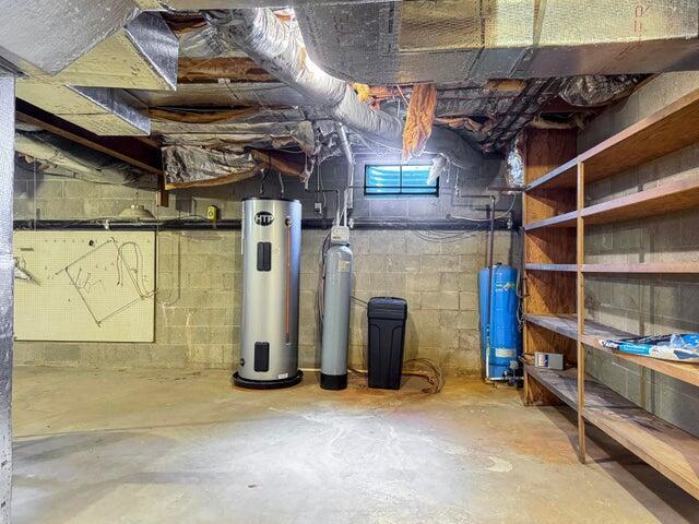 unfinished below grade area featuring water heater