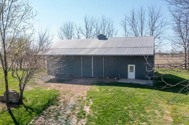 rear view of house with an outbuilding, an outdoor structure, and a yard