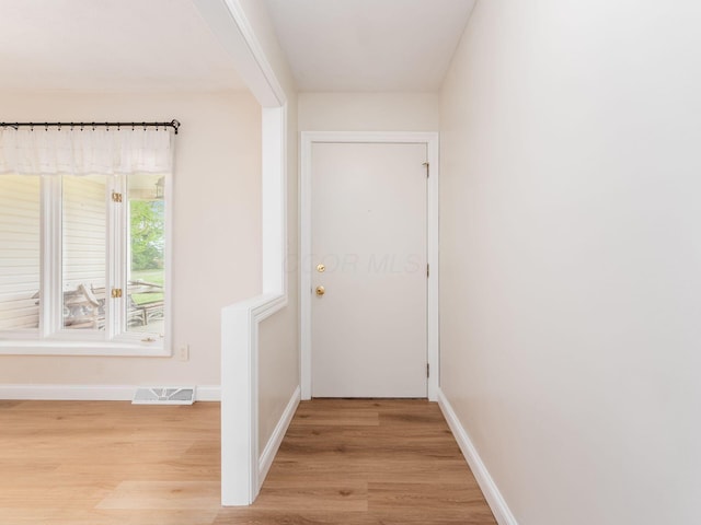 interior space featuring baseboards, visible vents, and light wood-style flooring