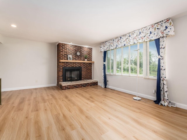 unfurnished living room featuring visible vents, a brick fireplace, baseboards, light wood-style floors, and recessed lighting