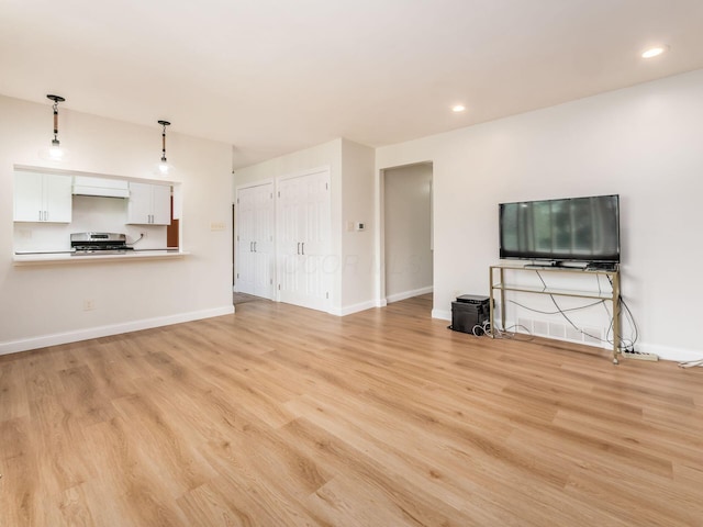 unfurnished living room featuring light wood-type flooring, recessed lighting, and baseboards