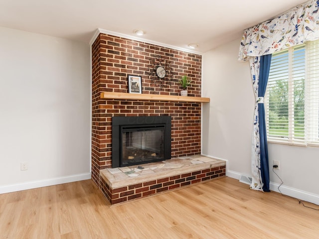 interior details featuring a brick fireplace, baseboards, and wood finished floors