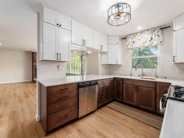 kitchen featuring a sink, light wood-style floors, stainless steel dishwasher, and light countertops