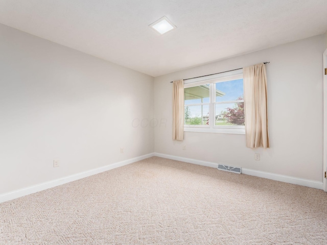 carpeted empty room featuring visible vents and baseboards