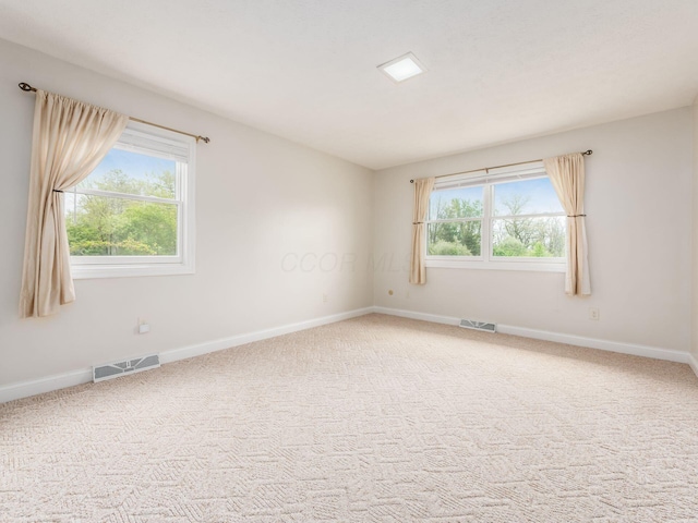 unfurnished room with baseboards, carpet floors, and visible vents